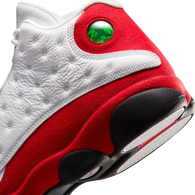 Close-up of white and red high-top sneaker with green eyelet and black outsole