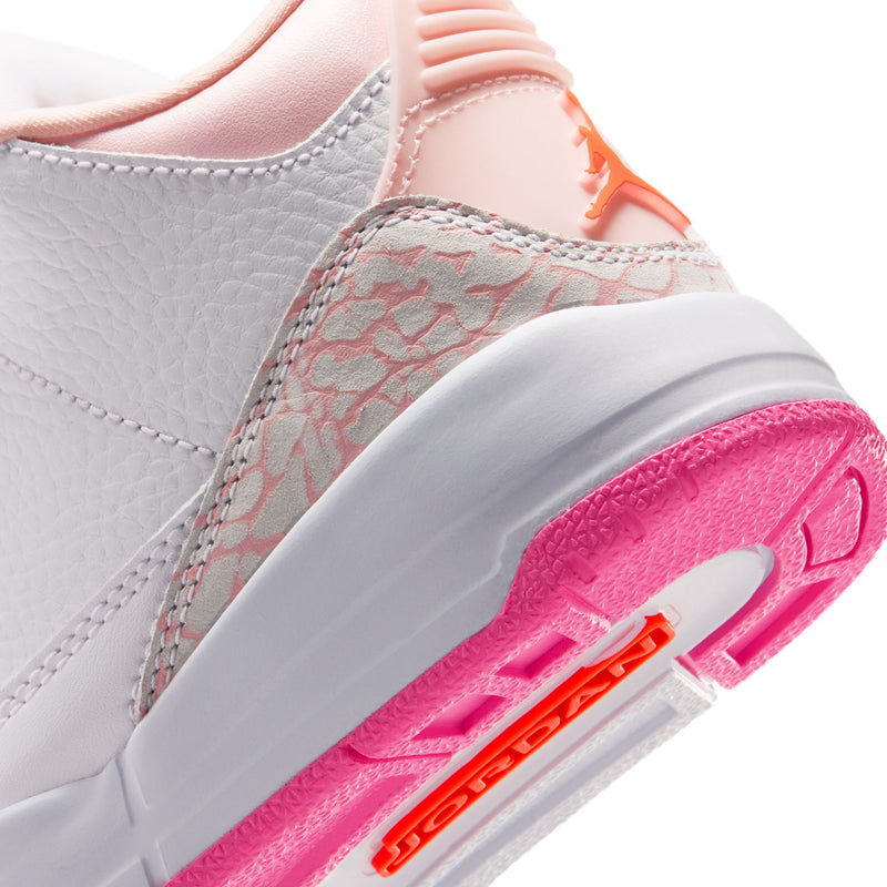 Kids sneaker side close-up, pink outsole with orange Jumpman detail and textured toe panel