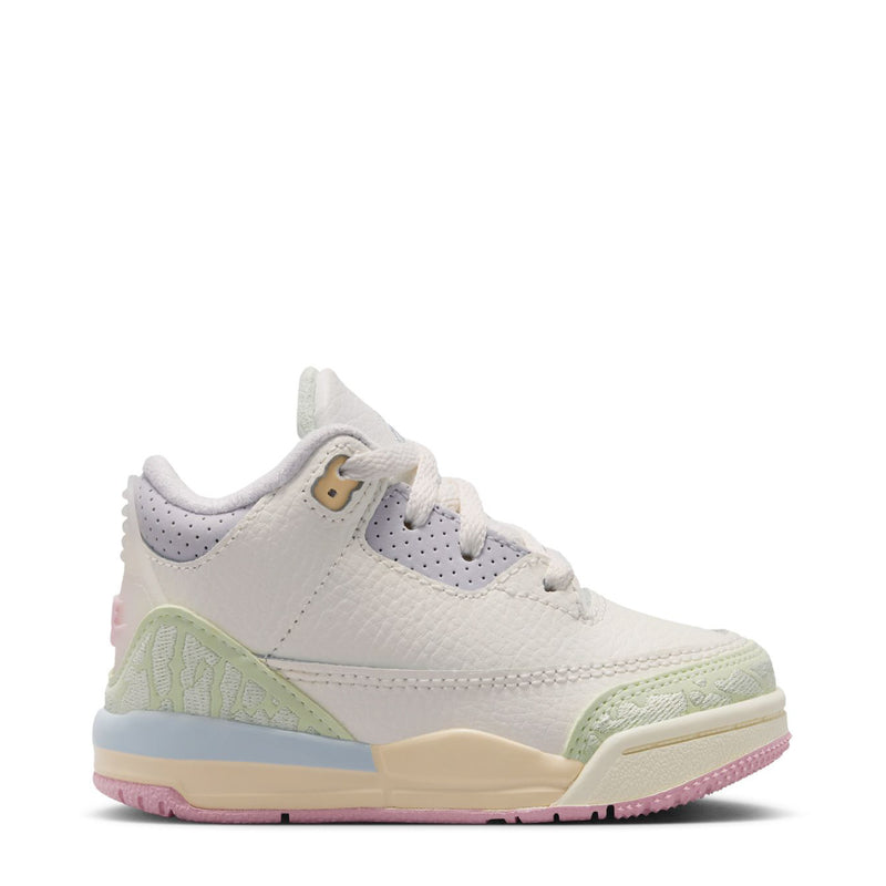 Toddler white sneaker with light blue, green, and pink accents, side profile