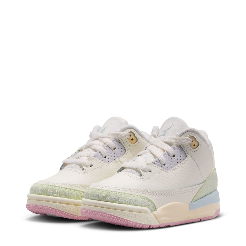Pair of toddler white low-top sneakers with green heel, pink outsole, and lace-up