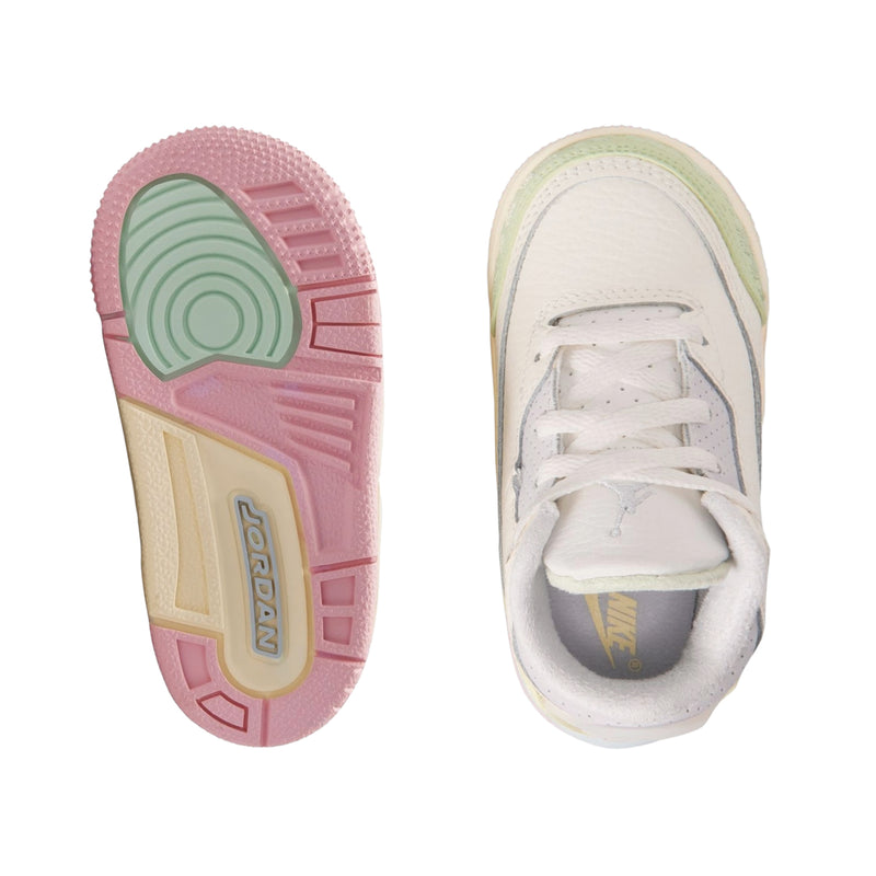 Toddler sneaker outsole and inside view in white with pink and green accents
