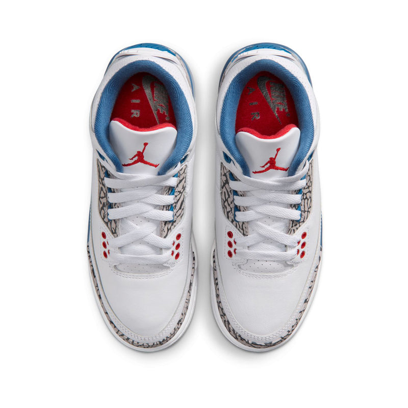 Youth white leather sneakers with blue trim and red Jumpman logo on the tongue lining
