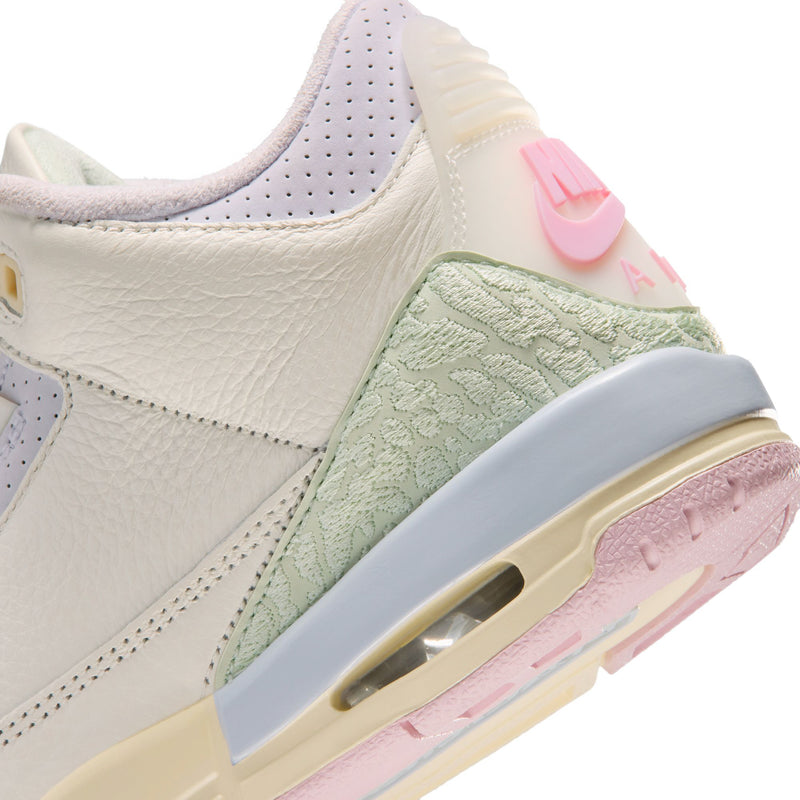 Youth sneaker side close-up, white upper with sage panel and pink accent Air sole