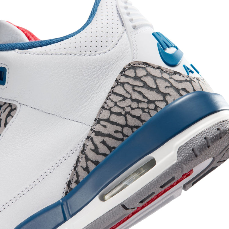 Youth white sneaker close-up with blue mudguard, elephant-print panel, and air window