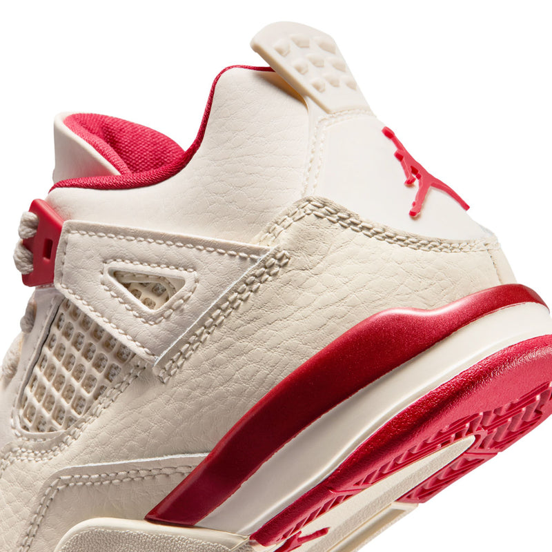 Kids shoe side close-up: pale ivory leather upper with red midsole and vented panels