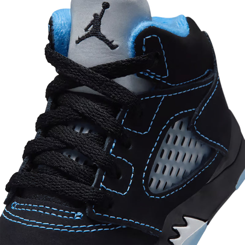 Close-up of toddler black sneakers with blue stitching, lace texture, and perforated side