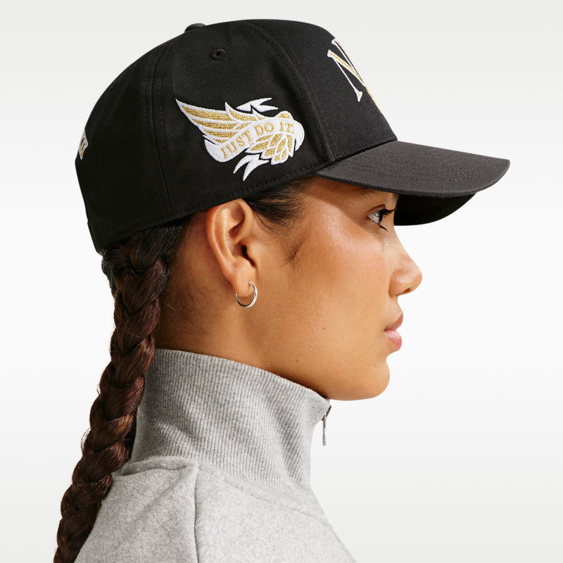 Black snapback cap with curved bill and side wing emblem embroidery