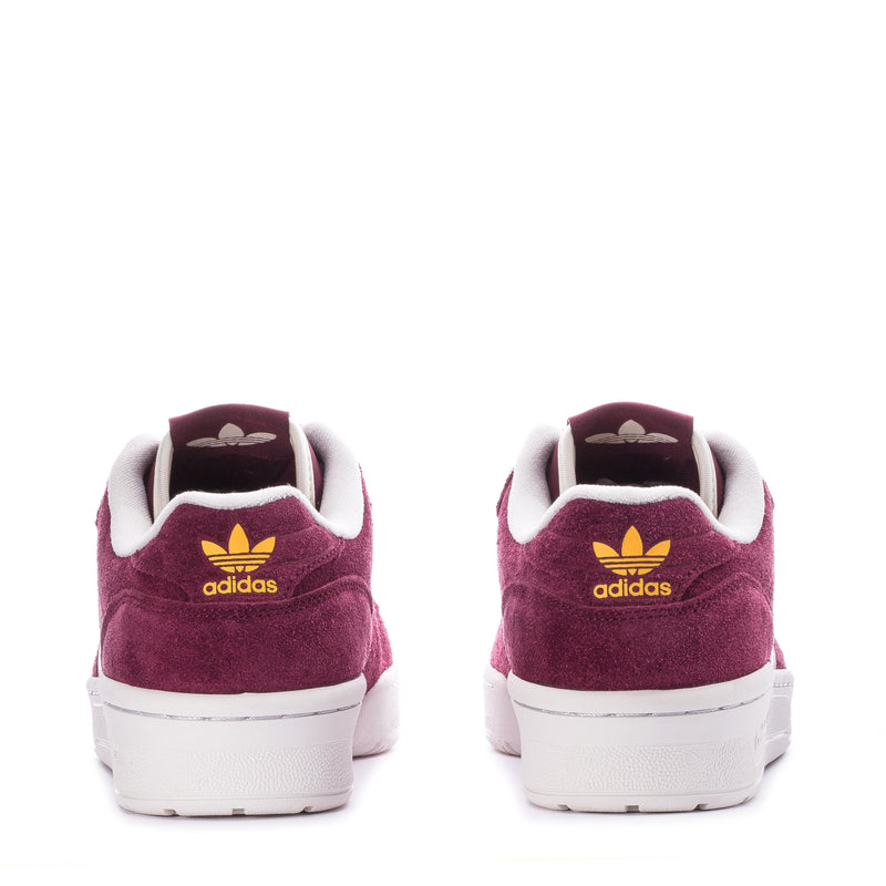 Men's burgundy suede low-top sneakers with adidas heel logo and white rubber sole.