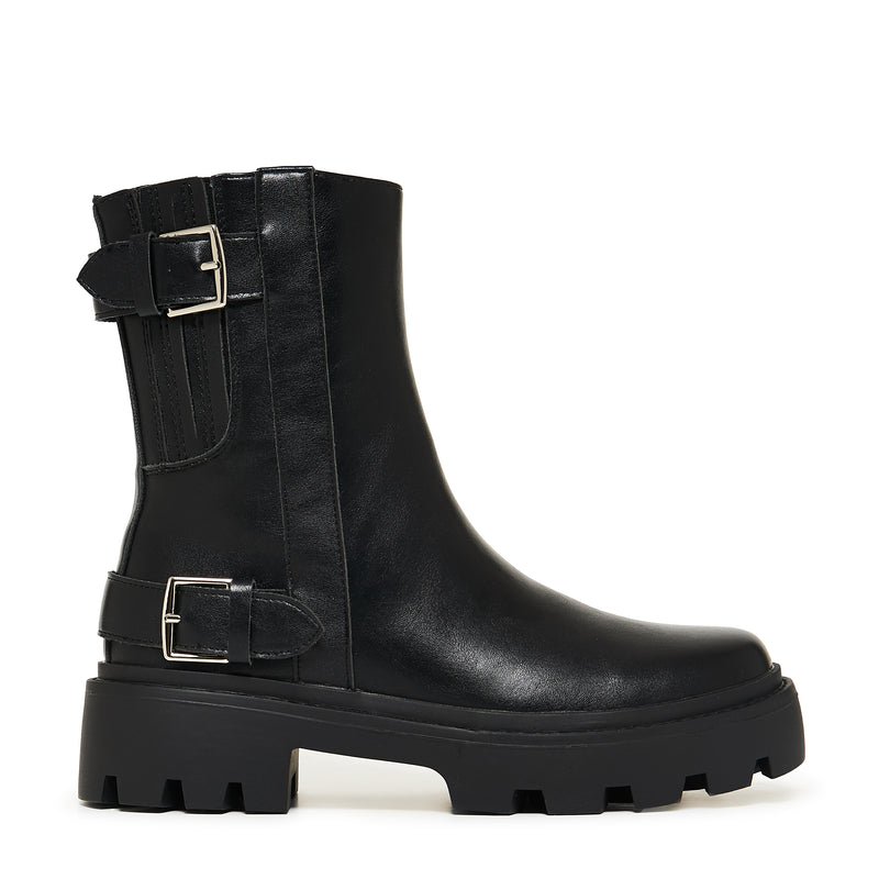 Black leather boot with buckle details on a white background