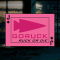 The "RUCK OR DIE" playing card features a bold pink design with an arrowhead, the phrase "GORUCK RUCK OR DIE," and a Jack of clubs symbol—ideal for rucking enthusiasts and dedicated members of the GORUCK community, showcased against a blurred room backdrop.