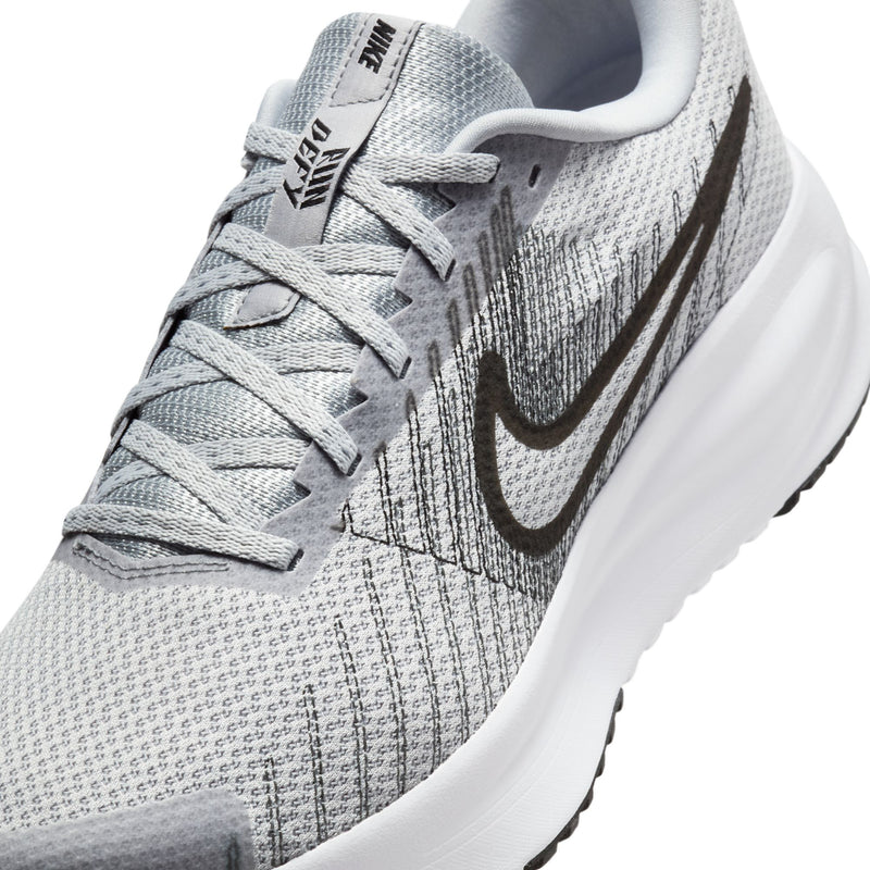 Men's running shoe upper close-up: grey knit texture, black swoosh, white lace panel.
