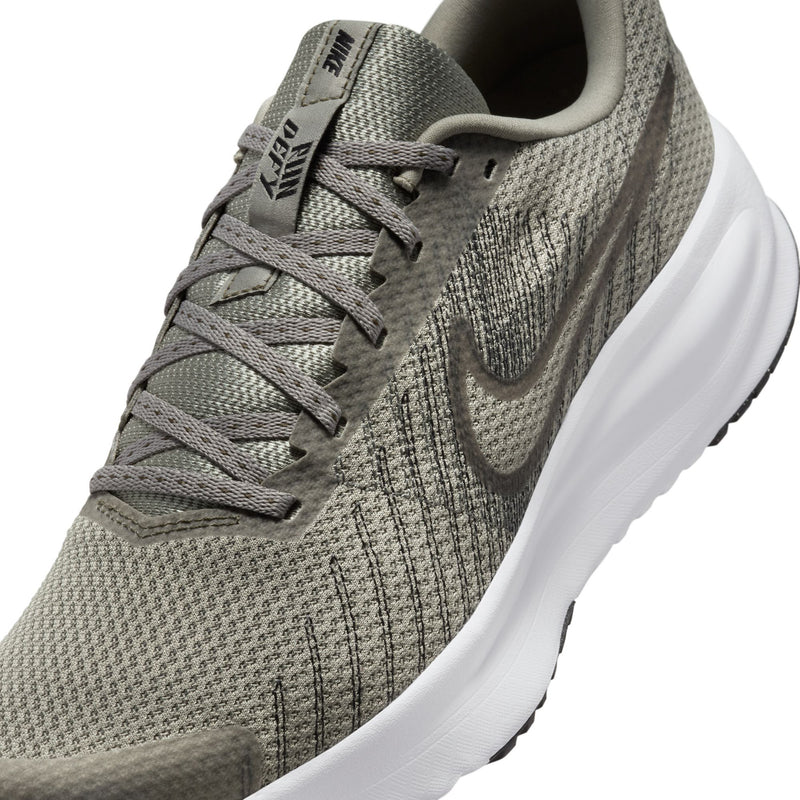 Close-up of men's running shoe upper with light gray mesh and dark swoosh logo