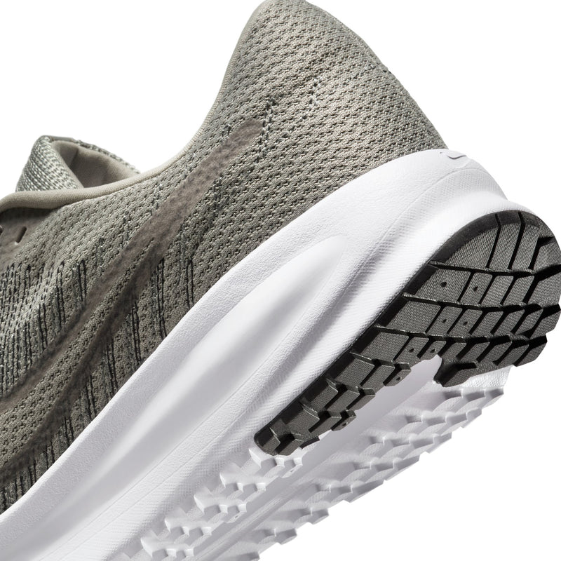 Side view close-up of men's running shoe with white midsole and textured outsole tread