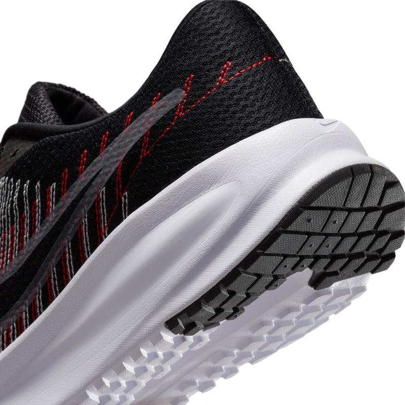 Close-up of black upper and white foam heel with treaded rubber outsole