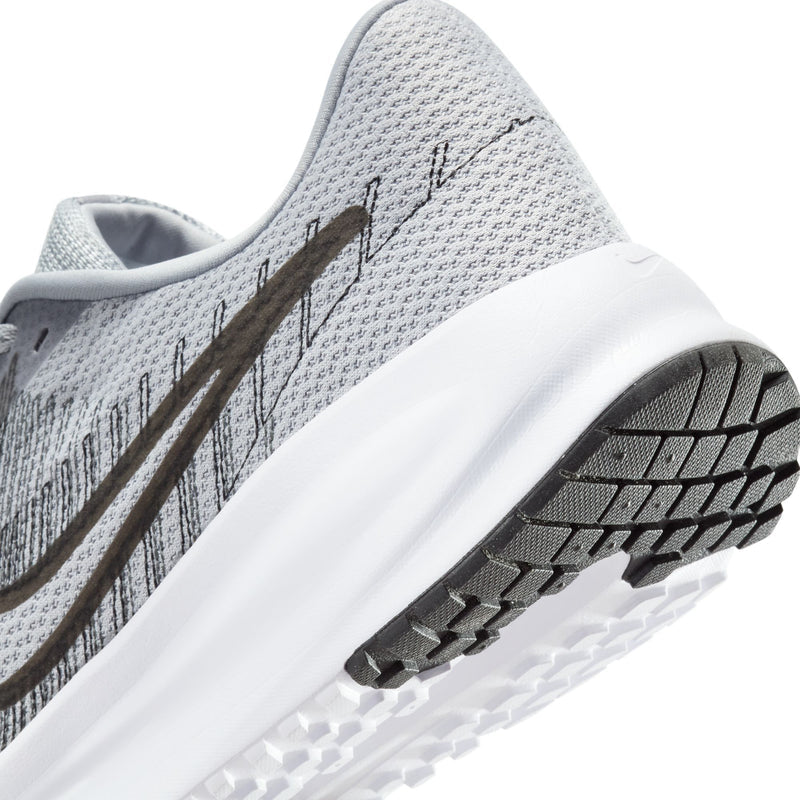 Men's running shoe side close-up: white midsole, black tread, grey knit upper.