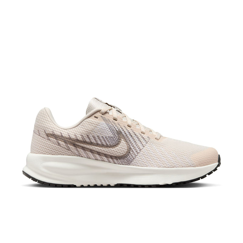 Light beige women's running shoe with lace-up knit upper and swoosh side logo.