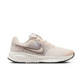 Light beige women's running shoe with lace-up knit upper and swoosh side logo.