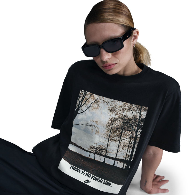 Black womens tee close-up: running photo graphic panel with 'THERE IS NO FINISH LINE'