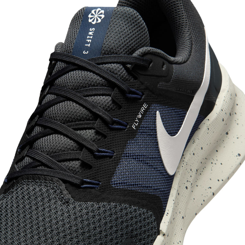 Mens lace-up running shoe close-up with dark knit upper, swoosh, and Flywire branding