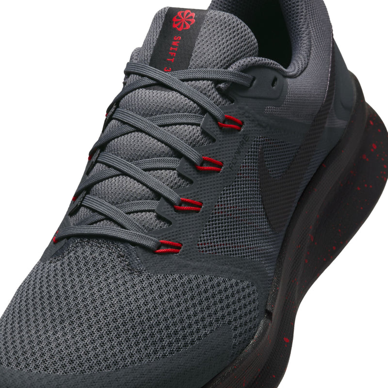 Close-up of men's dark gray running shoes with red lace loops and logo tongue