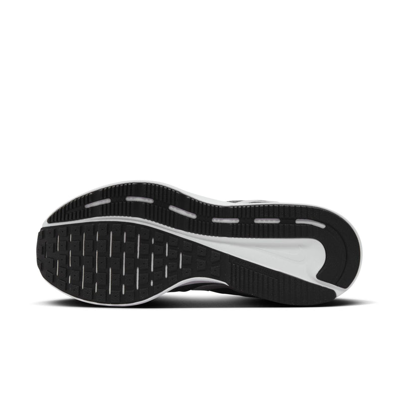 Outsole view with black traction tread and white sidewall on dark gray shoe