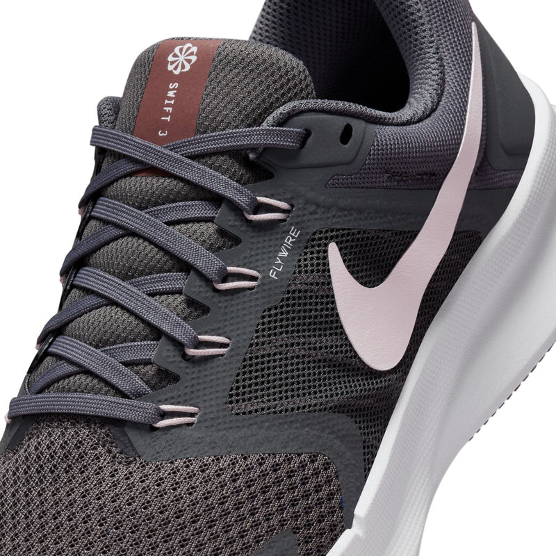 Close-up of dark gray knit running shoe with pink-lilac Swoosh and gray lace