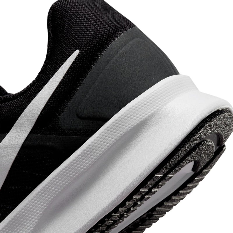 Black side view close-up with white midsole panel and textured rubber outsole edge.