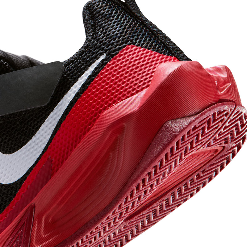 Kids black and red sneaker close-up of side swoosh and textured midsole