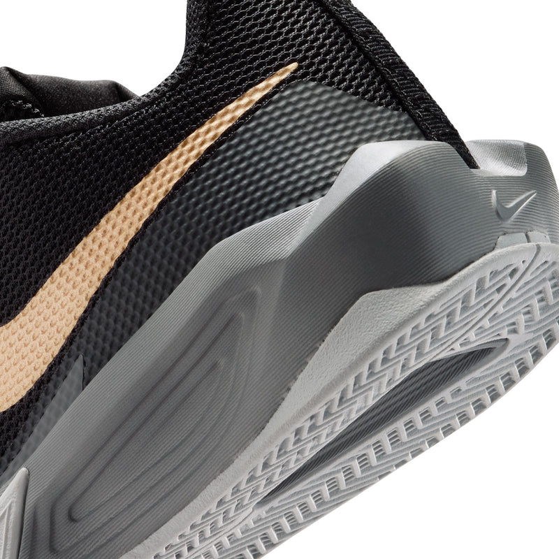 Youth basketball shoe close-up, black textured upper with gold stripe and gray outsole