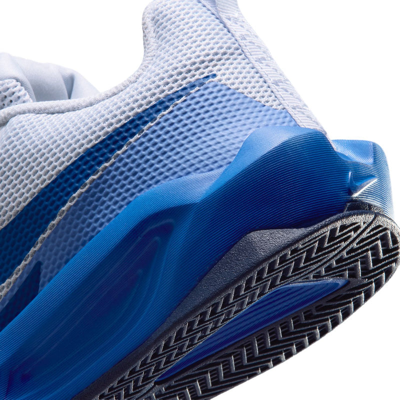 Close-up outsole and sidewall: dark navy tread with blue midsole on light gray shoe.