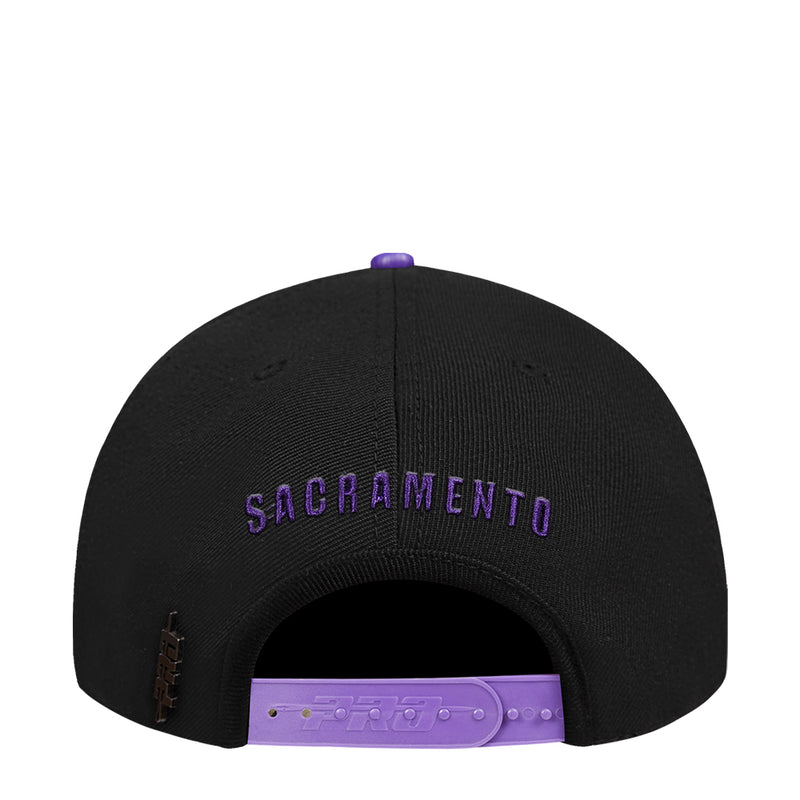 Black snapback cap underside view with purple lettering and adjustable strap
