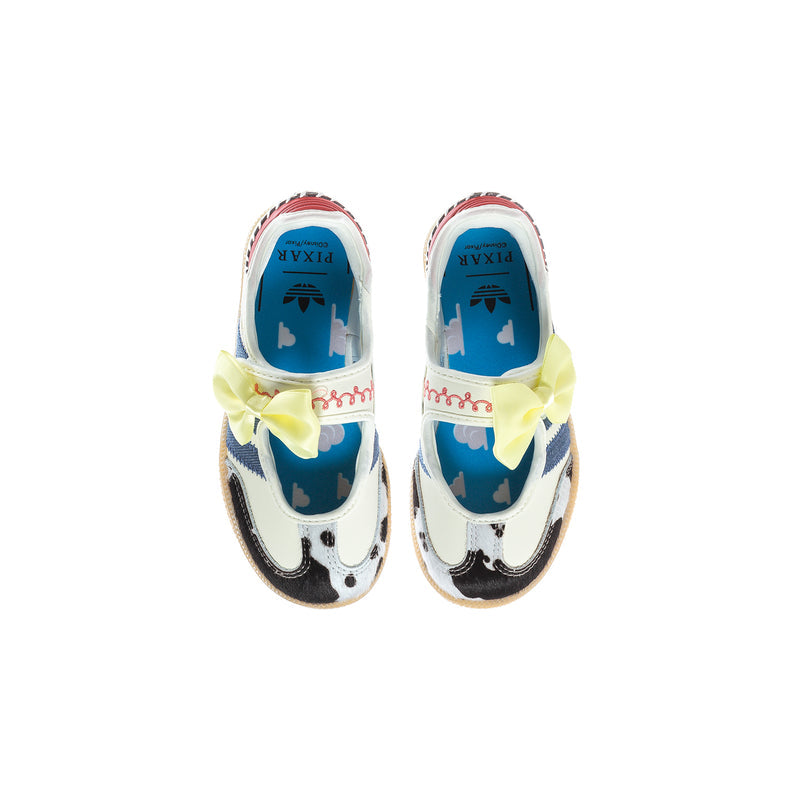 Kids sneakers with white uppers, yellow bow straps, blue interior lining, cow-print toe
