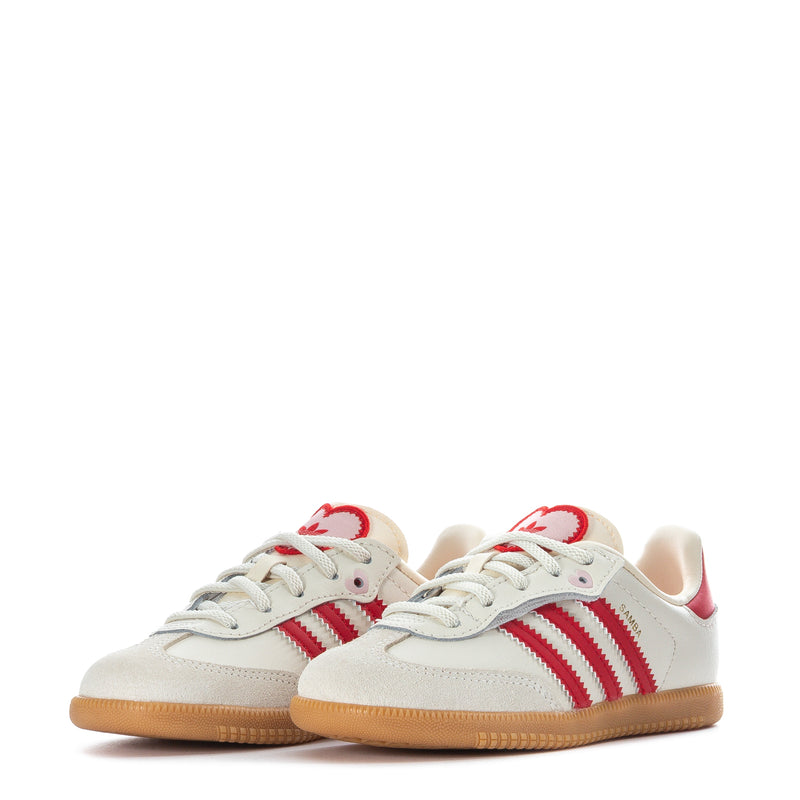 Pair of toddler cream sneakers with red stripes and gum rubber outsole