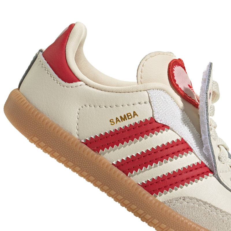 Toddler cream sneakers with red heel accent, red stripes, and gum outsole