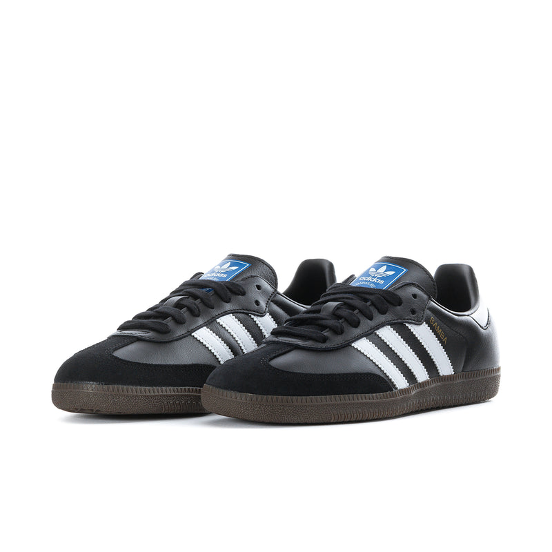 Pair of black adidas sneakers with white stripes, lace-up front and gum soles