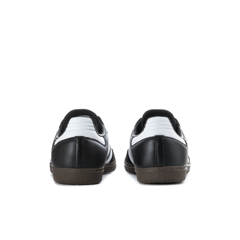 Black adidas sneakers with white heel detail and brown gum outsole, rear view