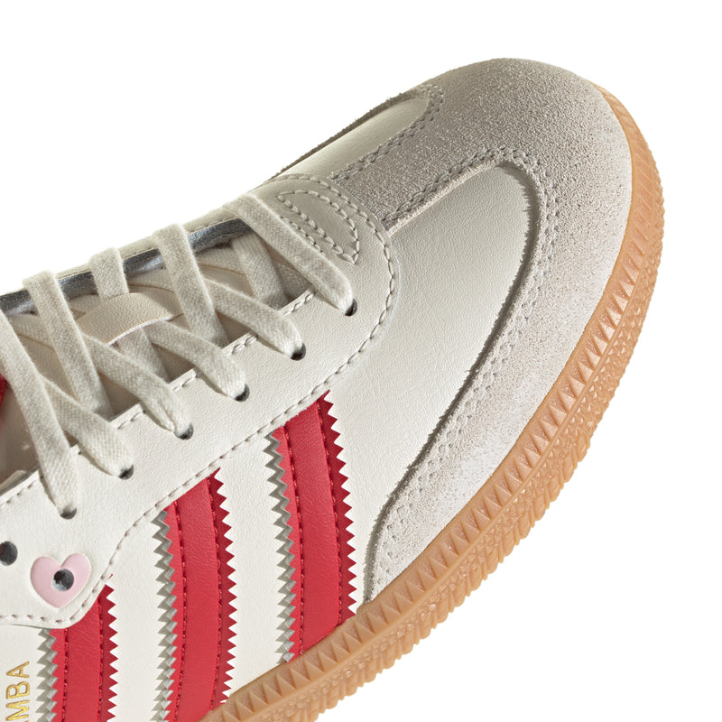 Youth adidas Samba OG sneaker upper close-up: cream suede with red striped panel