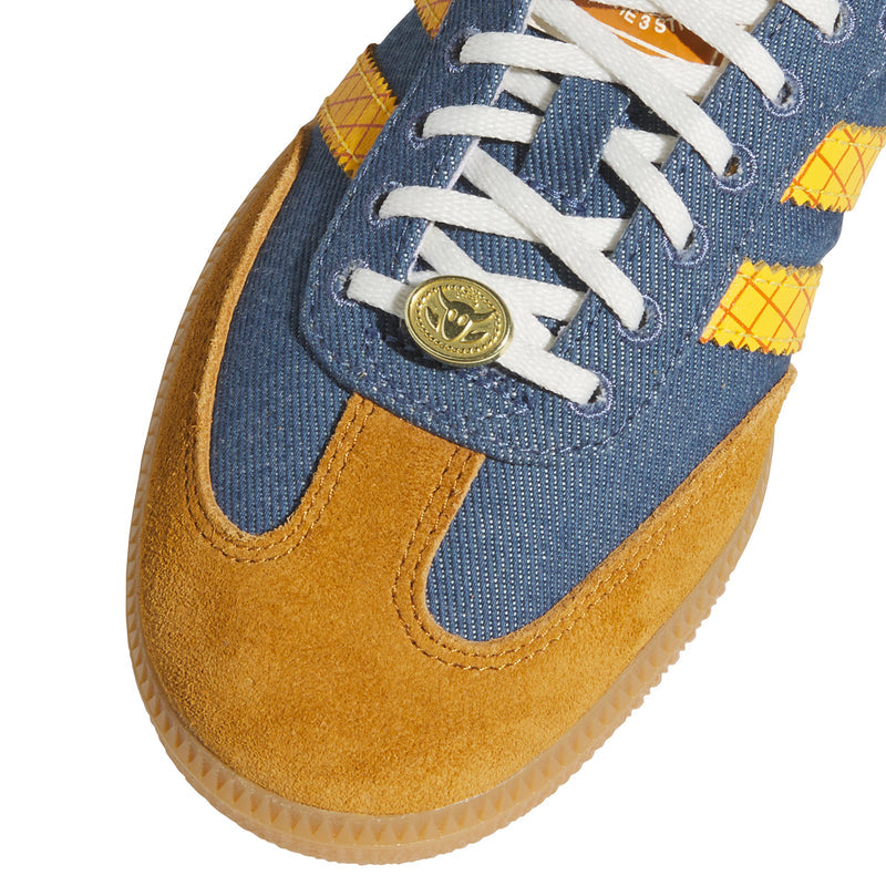 Close-up of kids' denim and mustard sneakers with white laces and emblem.