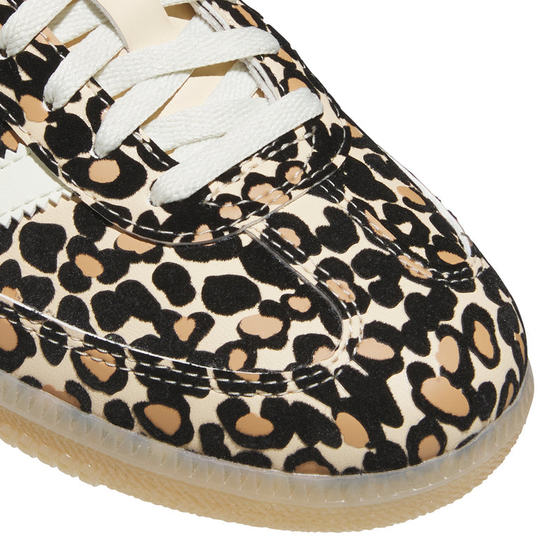 Youth sneaker close-up of leopard print upper with white laces and textured side panel