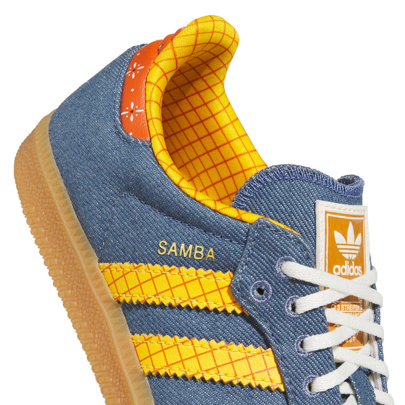 Close-up of kids' denim Samba sneaker with orange-yellow grid lining and adidas patch.