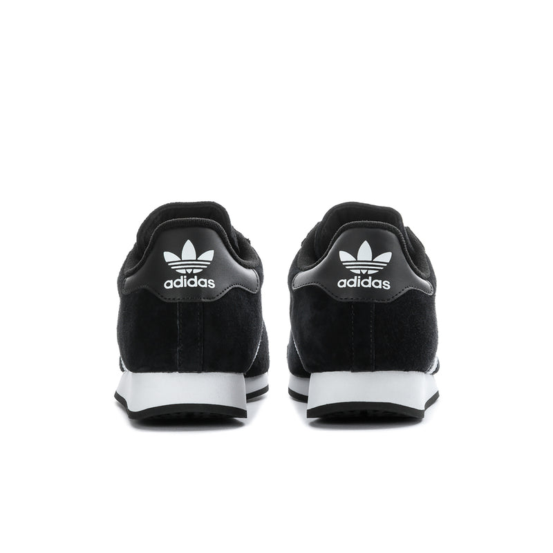 Black suede sneakers with adidas logo on heels and white midsole