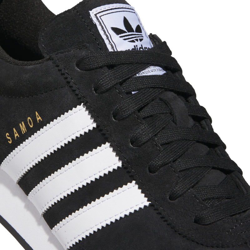 Black suede upper close-up with white three stripes and SAMOA lettering on side