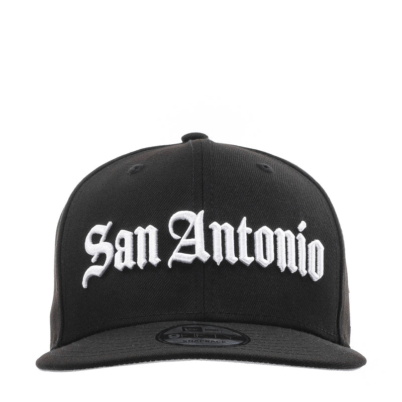 Black baseball cap with white "San Antonio" script logo on front, flat brim