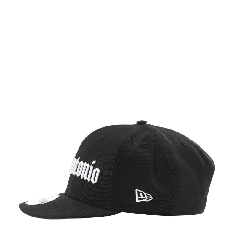 Black baseball cap with partial white logo script and New Era flag on side, curved brim