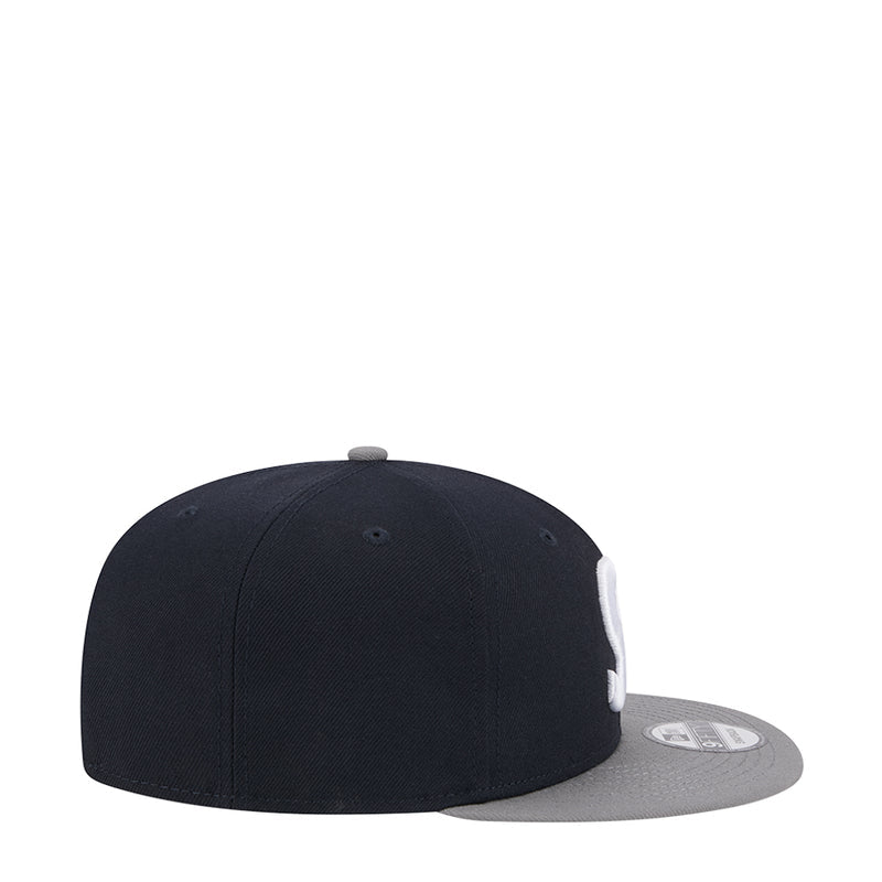 Two-tone snapback cap, dark crown with gray brim and small back label