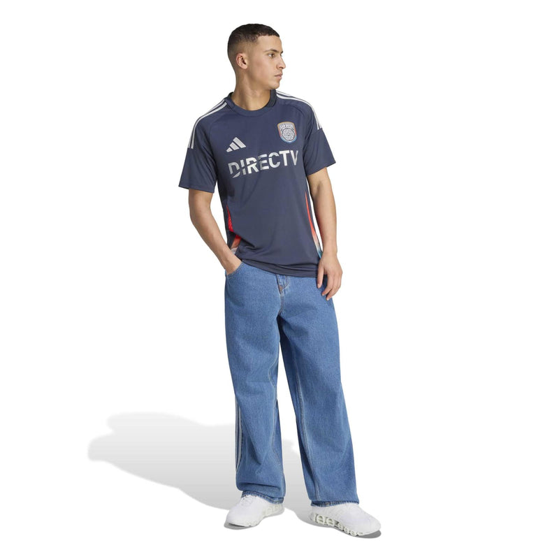 Men's navy replica home soccer jersey on model, with club crest and DIRECTV sponsor