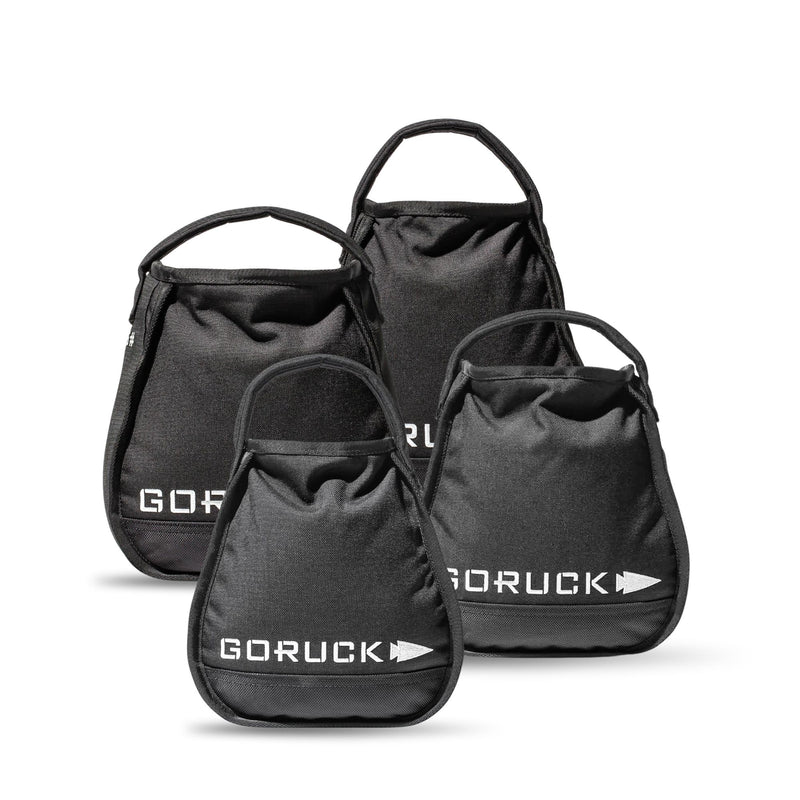 Four black GORUCK Kettlebell Bundle sandbags of different sizes with handles, grouped on a white background—each built tough like portable sand kettlebells and backed by a lifetime guarantee.