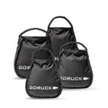Four black GORUCK Kettlebell Bundle sandbags of different sizes with handles, grouped on a white background—each built tough like portable sand kettlebells and backed by a lifetime guarantee.