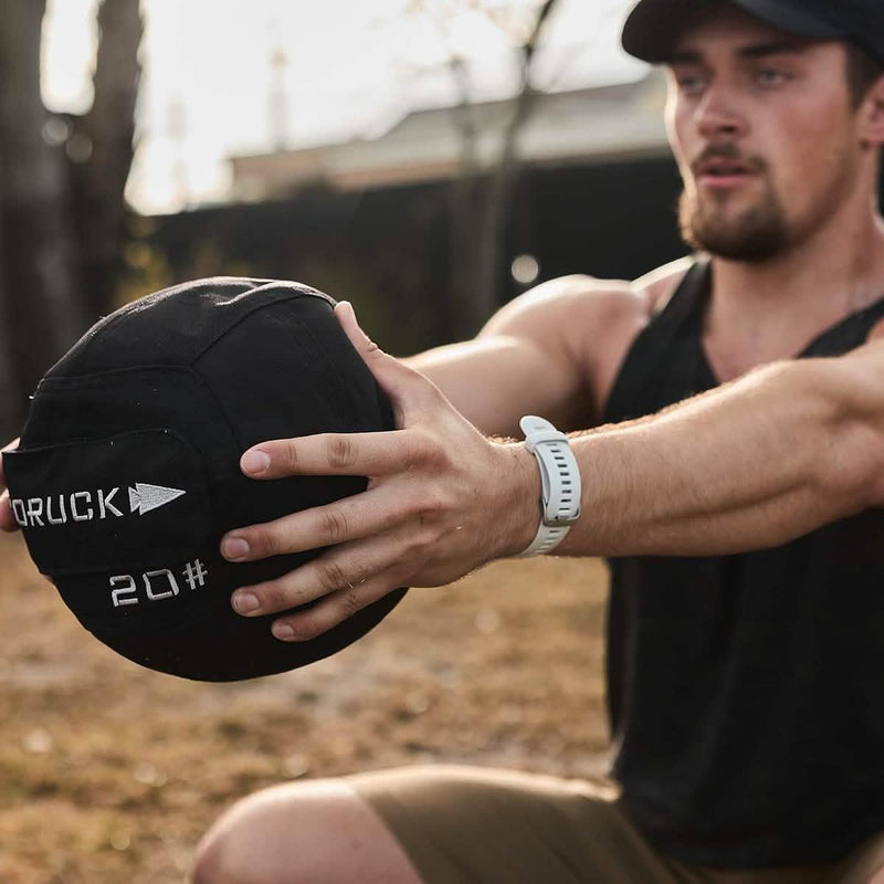 Man training outdoors with GORUCK branded 20 lb ruck weight, fitness and rucking gear