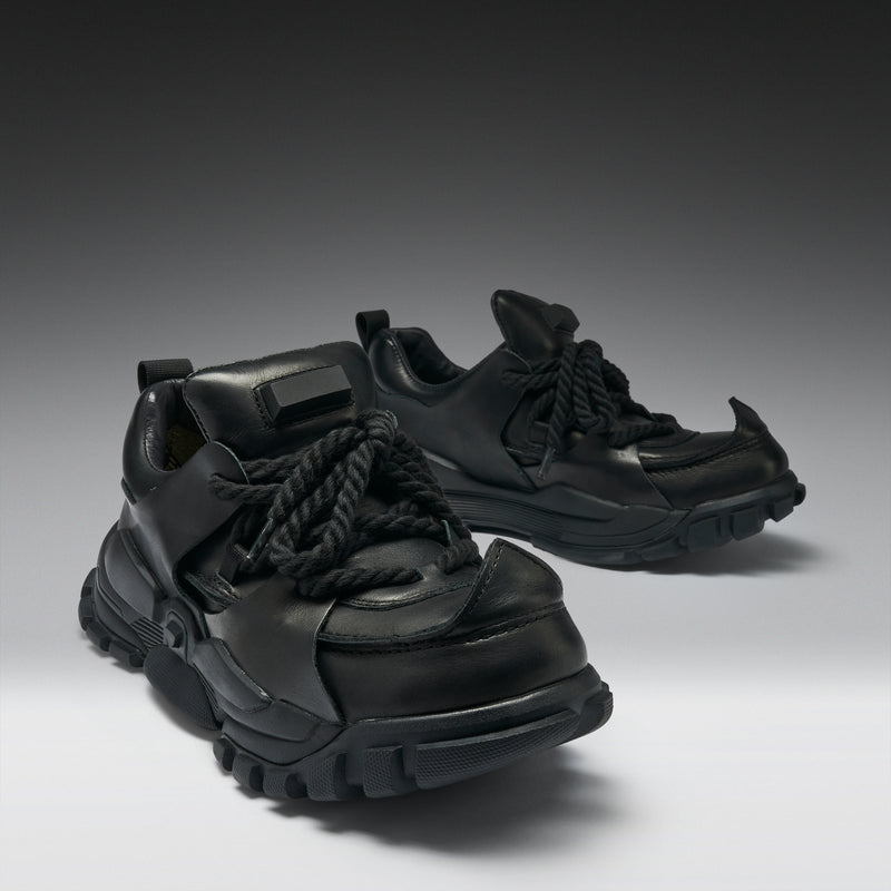 Pair of black sneakers on a gradient background